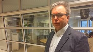 Jukka Mattila, ledande överläkare vid Lapplands centralsjukhus. En gråhårig man med glasögon och kavaj tittar in i kameran.