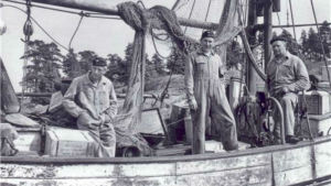 En konfiskerad trålare fylld med sprit i Sondarö år 1955. Sjöbevakare från sjöbevakningsstationen i Risholma. På bild från höger: Olavi Hotanen, Jalo Haapala, Pentti Hurri. En konfiskerad trålare fylld med sprit i Sondarö år 1955. Sjöbevakare från sjöbevakningsstationen i Risholma. På bild från höger: Olavi Hotanen, Jalo Haapala, Pentti Hurri.