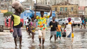 Människor går på översvämmad gata i Moçambique.