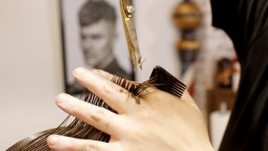 Mies leikkaa hiuksia.