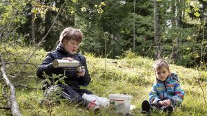 Marjaana Backman ja Arvi Henriksson kahvittelevat metsässä.
