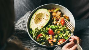 nainen syö kasvisruokaa