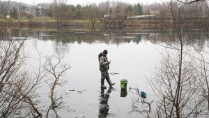 Mies pilkkii lammella.