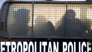 Pidätettyjä kiinalaisia miehiä poliisiautossa.