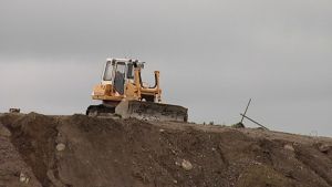 Kaivuri maankaatopaikalla.