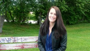 Nuori nainen istuu puistonpenkillä