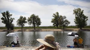 Nainen katselee kun ihmiset kalastavat Coruchessa Portugalissa.