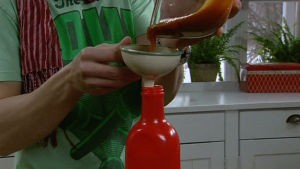 Paul häller upp hemgjord ketchup på flaska Paul häller upp hemgjord ketchup på flaska