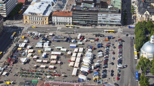 Ser du noga på bilden av Salutorget i Åbo hittar du en hel del bilar parkerade på torget. Det här vill planläggarna få bort. Flygbild över Salutorget i Åbo en livlig torgdag.