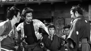 Kylän gangsterit uhittelevat samuraille (Toshiro Mifune) elokuvassa Yojimbo – onnensoturi
