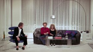 Pettyneet keski-ikäiset. Mukana Sandyn uusi 18-vuotias tyttöystävä (Carol Kane). Mies istuu nojatuolissa lasi kädessään, sohvalla mies ja nainen istuvat vierekkäin päät painuksissa. Jack Nicholson, Art Garfunkel ja Carol Kane elokuvassa Miehuusvuodet