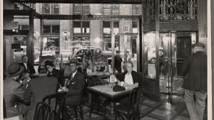 Café eller barinteriör i USA. Interiör på ett café eller en bar i USA. Interior with Windows and Flag and woman, 33rd st.