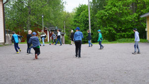 Dags för fotboll på rasten. Pojkar i lågstadieåldern spelar fotboll på en skolgård.