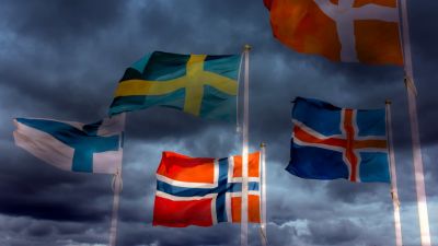 De nordiska flaggorna mot en hotfullt mörk himmel