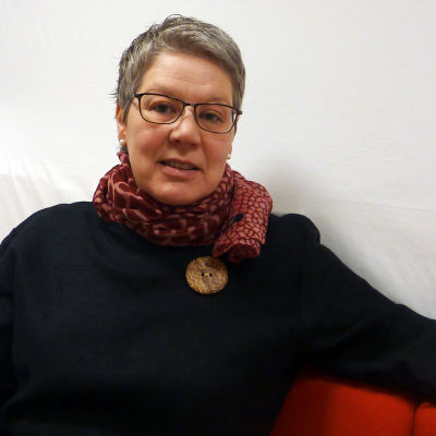 Camilla Grundström sitter i en soffa.