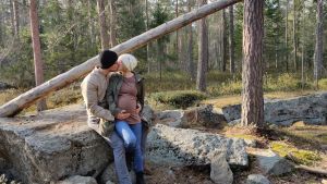 Så här såg det ut två timmar innan vattnet gick. En man och en gravid kvinna kramas och pussas i skogen. De lutar sig mot en sten.