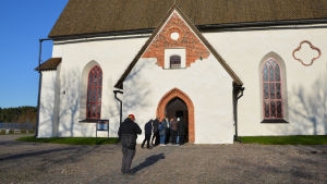 Flera turistgrupper besökte Borgå domkyrka på onsdagsförmiddagen. Jämfört med hur många resenärer som samlas på kyrkbacken om somrarna ser det förstås tomt ut ändå. Flera personer går in genom dörren till Borgå domkyrka.