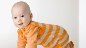 Barn födda i Finland 2010 var klädda i en del orange och gult. Ett barn kryper iklädd en orange tröja och randiga hängselbyxor. Kläderna är från moderskapsförpackningen 2011.