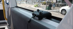 En xbox-kontroller ligger i fönstret på en självkörande buss i Fiskehamnen.