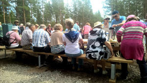 Vid de här borden och på de här bänkarna kommer publiken på Raseborgs sommarteater att dricka kaffe. Åskådare dricker kaffe och äter munk under pausen av Okänd soldat.