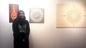 Amiirah Salleh-hoddin framför en serie målningar på utställningen i Östra centrum. Amiirah Salleh-hoddin på utställningen Islam ja minä.