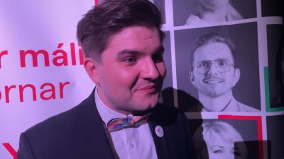 Daniel Arnarson står framför ett valplakat.