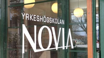 Yrkeshögskolan Novias logotyp klistras på ett fönster. Bilden tagen i Vasa. 