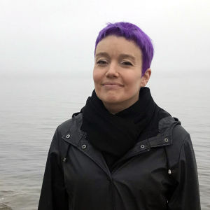 Karoliina Luoto seisoo kalliolla meren rannalla.