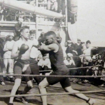 En svartvit bild med en boxningsmatch på ett lastfartyg.