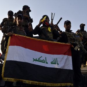 Irakiska elitsoldater firar fritagningen av Mosul och håller upp den irakiska flaggan på ett lastbilsflak.