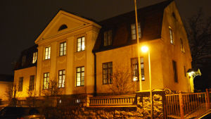 Biskopsgården har varit Bo-Göran och Karin Åstrands hem i ungefär ett halvår. Den nedre våningen används för att ta emot gäster medan paret Åströms privata bostad ligger på andra våningen. Ett stort rappat hus i två våningar upplyst av gatlampor.