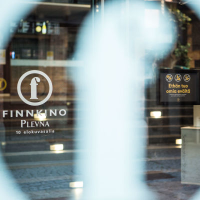 Finnkinon elokuvateatteri Plevnan julkisivu ja kyltti, jossa kielletään tuomasta omia eväitä. 18.6.2021. Finnkino päätti kieltää omien eväiden syömisen teattereissaan pandemian aiheuttamien tulonmenetysten takia.