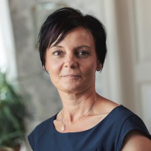 Sandra Alldén är Sjuksköterskeföreningens verksamhetsledare. Porträtt av mörkhårig medelålders kvinna i en mörkblå skjorta