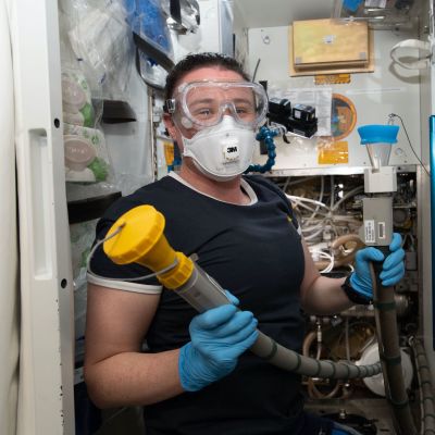 Toiletin huoltaminen ja siivoaminen on eräs avaruusaseman rutiinihommista. Tässä Serena Auñón-Chancellor on työn touhussa asiallisesti suojautuneena. 