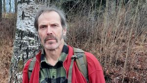 Alla kan göra något konkret för miljön, som till exempel att plantera ett träd, föreslår Leo Bergholm. Han vann tävlingen klimatsmarta Ingå med sitt förslag att kommunen går inför en trädplanteringskampanj. En medelålders man i rutig flanellskjorta och ryggsäck på ryggen står framför träd och buskar. Sen höst, brunt och grått.