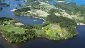 Fagernäs finns några kilometer nordväst om Lojo centrum mot Sammatti. En flygbild av ett område som omges av vatten. Det syns skog, åkrar och enstaka hus och vägar. Sommar och sol.