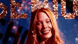 Sissy Spacek on Carrie. Sissy Spacek hymyilee prom queen -varusteissa kauhuelokuvassa Carrie.