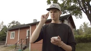 Antti Saario tutkii suupalaansa. Maistiaisena on rapea sirkka. Nuori mies katselee epäileväisen näköisenä sormiensa välissä olevaa pienen pientä hyönteistä. Toisessa kädessä on pieni kuppi.