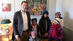 Lovisa stad har stött familjen sedan de anlände till staden. Flyktingbarn poserar tillsammans med Lovisa stadsdirektör.