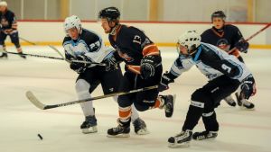 Hobbyserien South Coast hockey League tar paus till årsskiftet. (Arkivbild) Flera spelare försöker nå pucken.