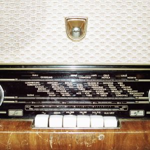 1960-luvun radion  etupaneeli, jossa on säätimet ja painikkeet (näppäin) sekä radiotaajuuksien merkit.