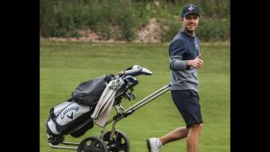 Rasmus Karlsson vill gå framåt i sin golfkarriär. Golfaren Rasmus Karlsson drar en golfkärra efter sig.