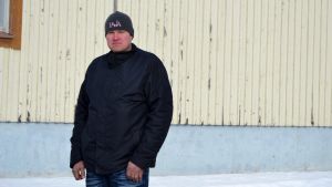 Jaakko Kallio är jordbrukare i tredje generation i Pettersbacka i Vörå. Men han ser sig mer som Ylihärmäbo än Vöråbo. Porträttfoto av man med svart jacka, svart mössa och blå jeans. Han tittar in i kameran. I bakgrunden en träbyggnad som är beigemålad. Snö syns också i bakgrunden.