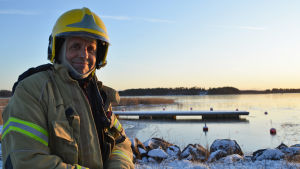 Det här var Jari Kankainens första svanuppdrag för i år, men de lär bli fler. En brandman tittar in i kameran och ler. Bakom honom syns en brygga och fruset vatten. Solen håller på att gå ner.