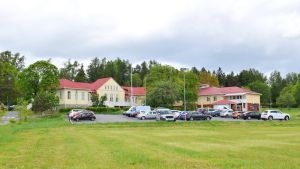 Almahemmet. Almahemmet i Kimito, grön gräsmatta och bilar på parkeringar framför huset.