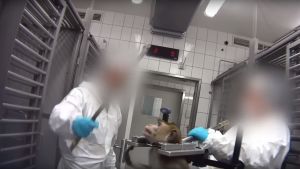 Bilderna från laboratoriet visar personal som behandlar djuren illa. Två laboratoriearbetare står runt en faststpänd apa. Deras ansikten är utsuddade.
