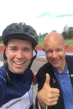 Daniel Olin klarade av att cykla 85 km från Helsingfors till Karis och mottogs av en glad Kaj Kunnas. Programledaren Daniel Olin med cyklehjälm på huvudet tillsammans med sportjournalisten Kaj Kunnas på en idrottsplan i Karis.