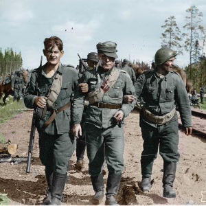 Sårade soldater går i armkrok längs ett järnvägsspår.