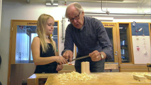 Bjarne Sund hjälper Leah Edberg under en slöjdlektion. En äldre man hjälper en elev i skolan slöjdsal.