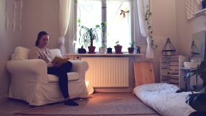 Cecilia Weckström är minimalist och tycker att hon har mer tid över till sådant hon mår bra av, med färre saker. Cecilia Weckström sitter i en vit fotölj och läser bok i sitt ljusa och lilla rum.